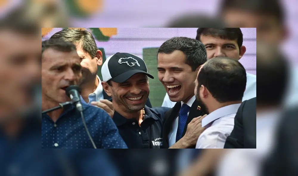 Venezuelan opposition leader and self-proclaimed interim president Juan Guaido (C-R) shares a laugh with also opposition leader Henrique Capriles (C-L) as they and local and regional leaders address the crowd to give details of what Guaido calls "Operation Freedom" during a rally in Caracas on March 27, 2019. - Desperation and rage spreads among Venezuelans as the hours pass and the massive blackout that hits the country since Monday is not solved. A new blackout swept across Venezuela on Monday, including much of Caracas, sowing alarm two weeks after a nationwide outage that paralyzed the country. (Photo by Yuri CORTEZ / AFP)