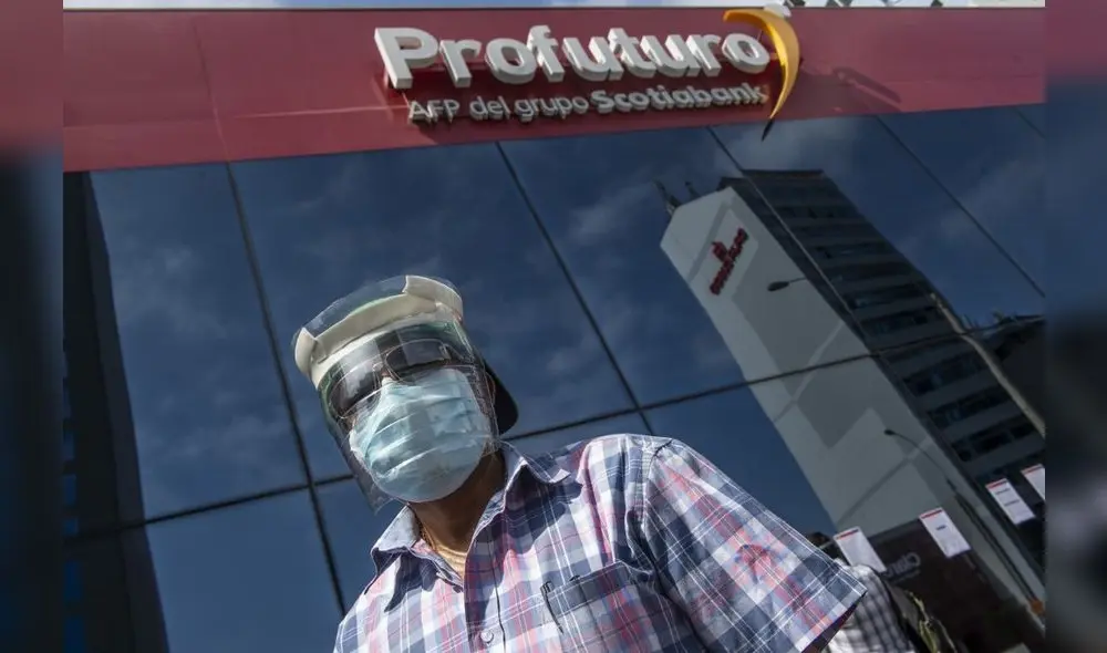 A man looks for information at the front door of Profuturo AFP (Pension Fund Administration) office in Lima on May 18, 2020. - More than six million Peruvians can request as of Monday the withdrawal of up to 3,700 US dollars from their pension funds to alleviate the economic crisis caused during the two months lockdown imposed by the government to fight the spread of the novel Covid-19 coronavirus. (Photo by ERNESTO BENAVIDES / AFP)