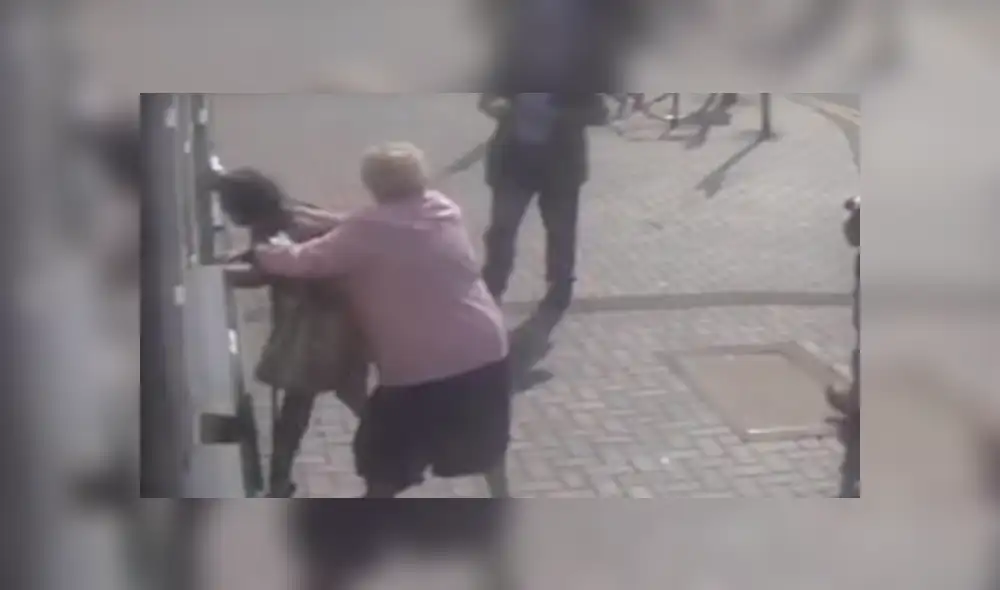 Dos hombres se quedaran viendo el incidente sin hacer nada por defender a la anciana. Foto: captura Dos hombres se quedaran viendo el incidente sin hacer nada por defender a la anciana. Foto: captura