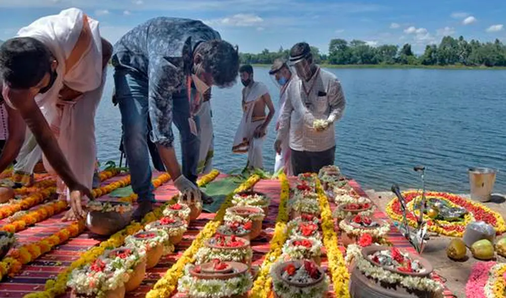 En la aldea de Belakavadi, a unos 125 km de Bangalore, la orilla del río aparecía engalanada con flores rojas y guirlandas de caléndulas amarillas. Foto: AFP En la aldea de Belakavadi, a unos 125 km de Bangalore, la orilla del río aparecía engalanada con flores rojas y guirlandas de caléndulas amarillas. Foto: AFP