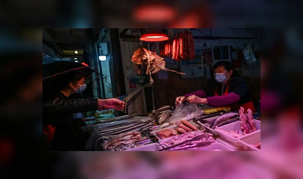 Customers buy food from a vendor (R) at a meat stall in Wuhan in China's central Hubei province on April 18, 2020. (Photo by Hector RETAMAL / AFP) Customers buy food from a vendor (R) at a meat stall in Wuhan in China's central Hubei province on April 18, 2020. (Photo by Hector RETAMAL / AFP)