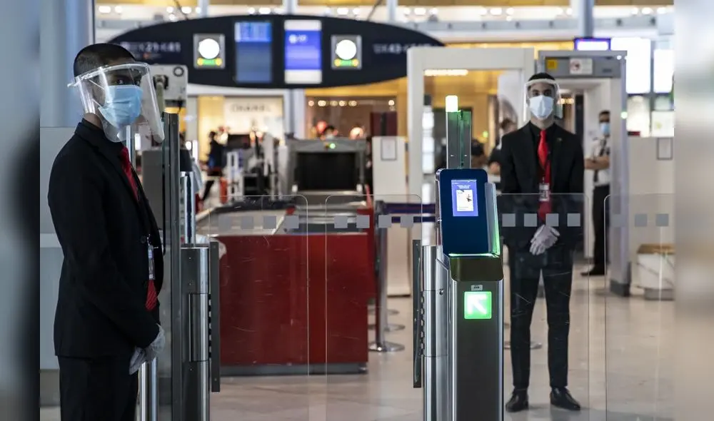 (FILES) In this file photo taken on May 14, 2020 Charles de Gaulle airport personnel wear protective face masks and visors in Terminal 2 of Charles de Gaulle international airport in Roissy near Paris, as France eases lockdown measures taken to curb the spread of the COVID-19 (the novel coronavirus). - France will halt all travel from Britain for 48 hours from midnight December 20, 2020, including journeys "related to goods transport by road, air, sea or rail", the prime minister's office said, after a new fast-spreading strain of coronavirus appeared in the UK. (Photo by Ian LANGSDON / POOL / AFP)
