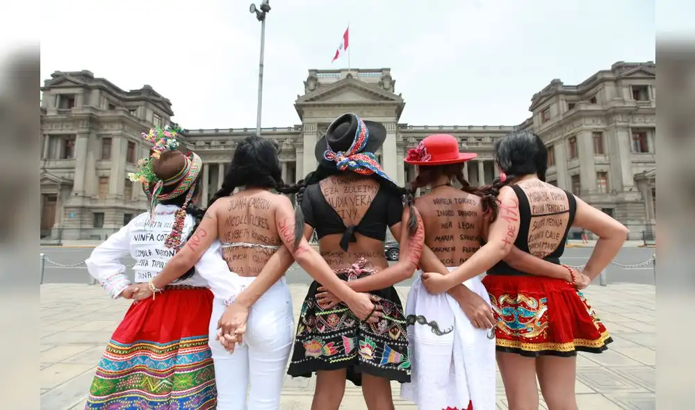 Feministas con nombres de víctimas de feminicidio en sus espaldas.