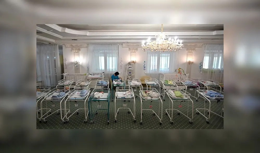 A nurse cares for newborn babies at Kiev's Venice hotel on May 15, 2020. - More than 100 babies born to surrogate mothers have been stranded in Ukraine as their foreign parents cannot collect them due to border closures imposed during the coronavirus pandemic, authorities said on May 14. (Photo by Sergei SUPINSKY / AFP)