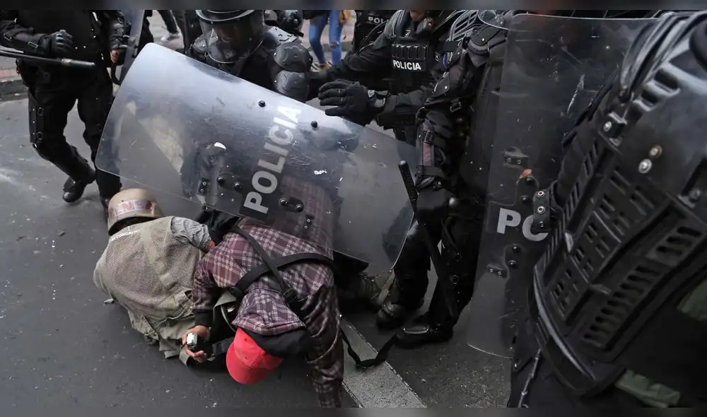 Periodistas del periódico El Comercio son atacados por la policía durante una protesta en Quito.