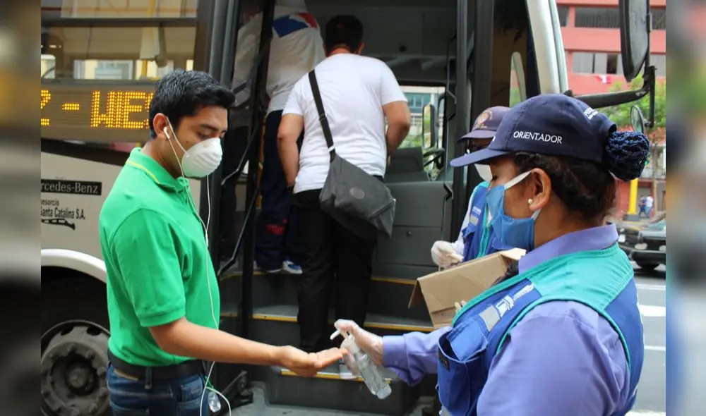 Los usuarios se desinfectan las manos y suben al bus usando tapabocas.