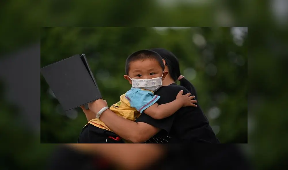 A mother holds his son next to Yangtze River in Wuhan, in China�s central Hubei province on May 12, 2020. - Wuhan plans to conduct coronavirus tests on the Chinese city's entire population after new cases emerged for the first time in weeks in the cradle of the global pandemic, state media reported on May 12. (Photo by Hector RETAMAL / AFP) A mother holds his son next to Yangtze River in Wuhan, in China�s central Hubei province on May 12, 2020. - Wuhan plans to conduct coronavirus tests on the Chinese city's entire population after new cases emerged for the first time in weeks in the cradle of the global pandemic, state media reported on May 12. (Photo by Hector RETAMAL / AFP)