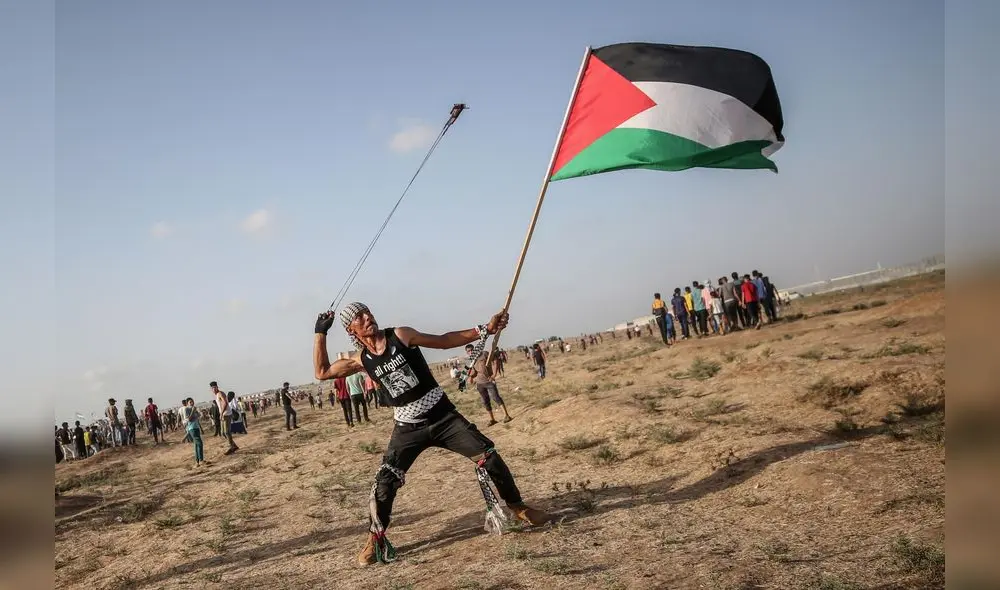 Gaza Strip (---), 12/07/2019.- A protester carries the Palestinian flag as he hurls stones with a slingshot near the border between Israel and the Gaza Strip, in the eastern Gaza Strip, 12 July 2019. (Protestas) EFE/EPA/MOHAMMED SABER Gaza Strip (---), 12/07/2019.- A protester carries the Palestinian flag as he hurls stones with a slingshot near the border between Israel and the Gaza Strip, in the eastern Gaza Strip, 12 July 2019. (Protestas) EFE/EPA/MOHAMMED SABER