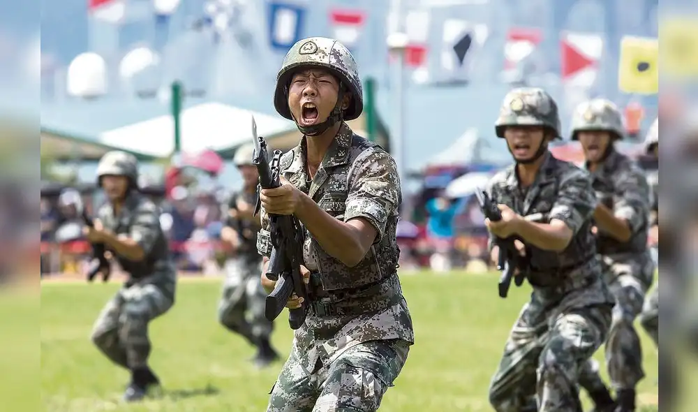 (FILES) This file photo taken on June 30, 2019 shows China's People's Liberation Army (PLA) soldiers performing drills during a demonstration at an open day at the Ngong Shuen Chau Barracks on Stonecutters Island in Hong Kong to mark the 22nd anniversary of Hong Kong's handover from Britain to China. - Videos falsely claiming to show a Chinese military crackdown against pro-democracy protesters in Hong Kong have flooded social media over the past week, according to an AFP investigation that has debunked multiple posts. The PLA has maintained a garrison in Hong Kong since the former British colony was returned to China in 1997, with an estimate of 8,000-10,000 PLA troops in the territory. (Photo by ISAAC LAWRENCE / AFP) / TO GO WITH HongKong-politics-internet-military,FOCUS by Cat Barton and Rachel Yan