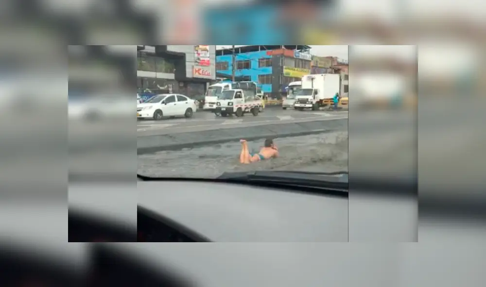 Mujer se baña en charco de agua en plena autopista
