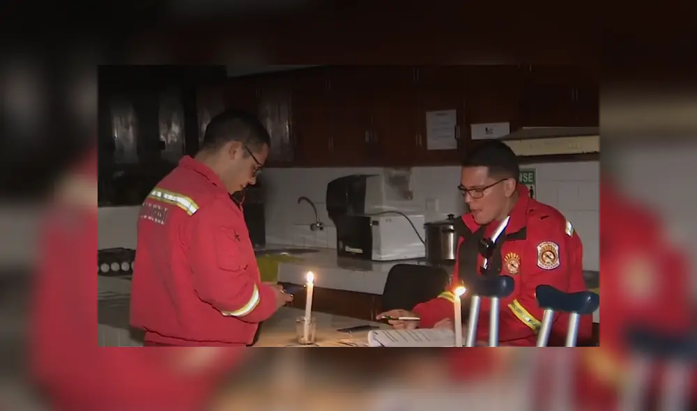 Bomberos se alumbran de velas para realizar sus informes. Foto: captura