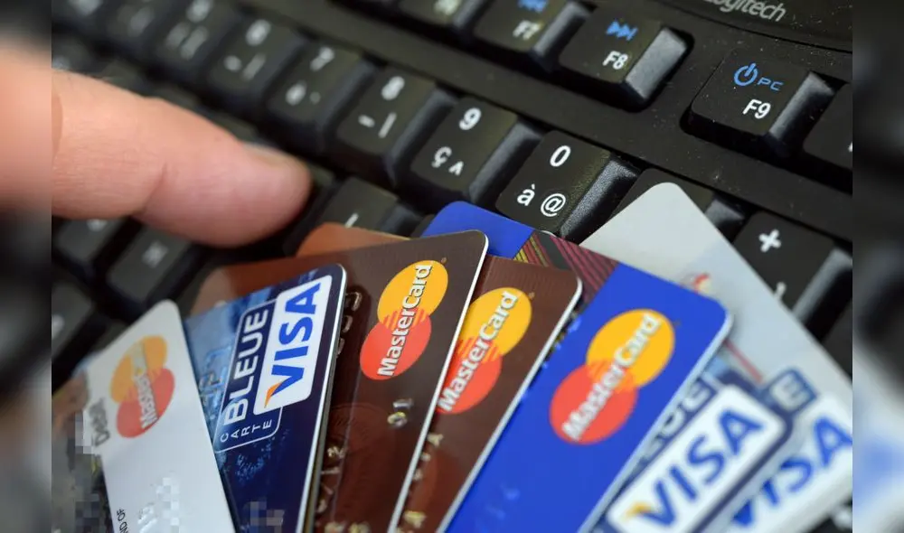 Credit cards are pictured on a computer's keyboard on February 5, 2013  in Rennes, western France. French police has arrested, early this morning in Paris and in several French and overseas departments, 22 people in connection with the trade of credit cards numbers on internet.  AFP PHOTO DAMIEN MEYER (Photo by DAMIEN MEYER / AFP)