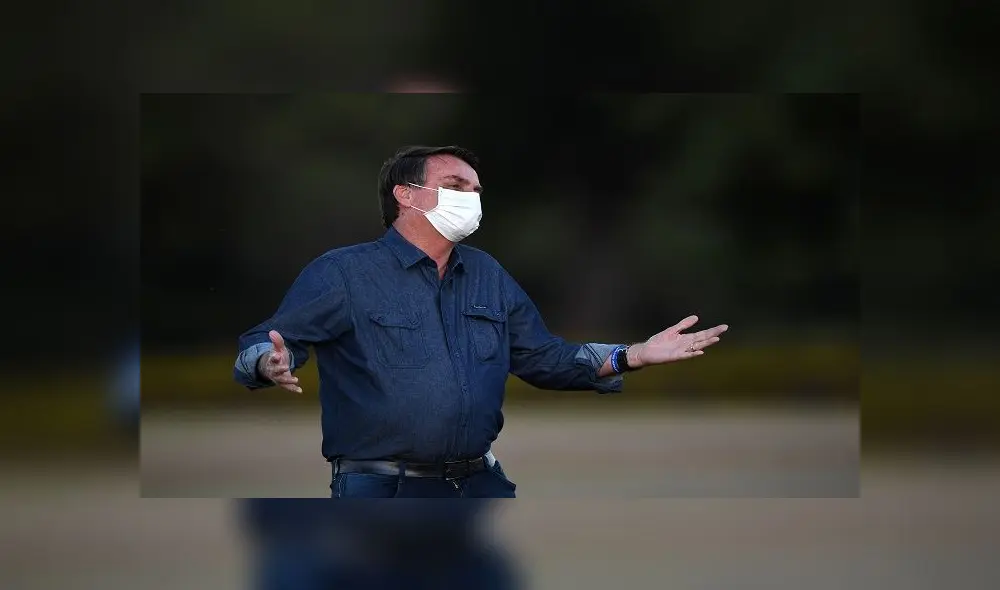 Brazilian President Jair Bolsonaro gestures while attending the flag unveiling ceremony at the Alvorada Palace in Brasilia, on July 15, 2020. - Brazil President Jair Bolsonaro tested positive for coronavirus again, CNN Brazil said on Wednesday, quoting the far right leader, who underwent a new test on Tuesday. (Photo by EVARISTO SA / AFP)