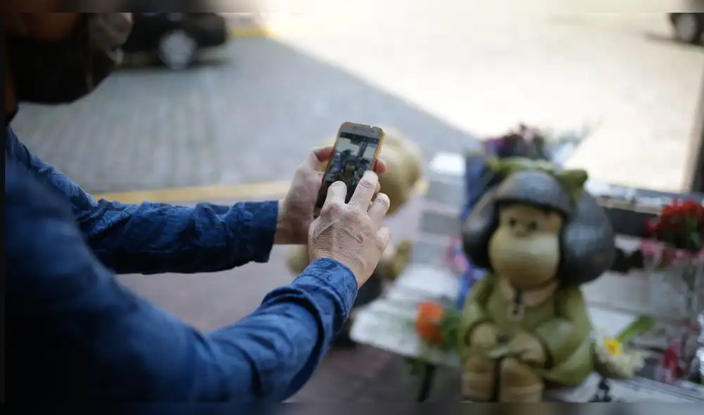 Diversas personas en Argentina se acercan a la estatua de Mafalda para recordar al popular 'Quino'. Foto: EFE / Juan Ignacio Roncoroni.