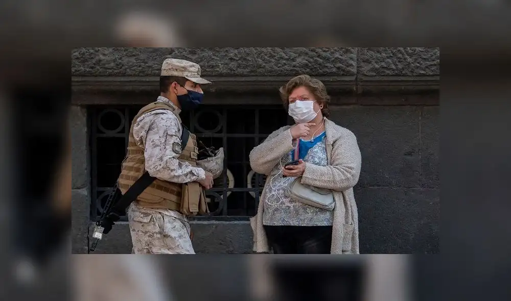 A soldiers and a woman wear face masks against the spread of coronavirus as they remain at a checkpoint at Plaza de Armas square in Santiago, Chile, May 06, 2020. - Chile's health authorities tightened mandatory confinement measures in Santiago on Wednesday, in the face of an increase in coronavirus cases, totaling 23,048 infected and 281 deaths in the country. (Photo by Martin BERNETTI / AFP) A soldiers and a woman wear face masks against the spread of coronavirus as they remain at a checkpoint at Plaza de Armas square in Santiago, Chile, May 06, 2020. - Chile's health authorities tightened mandatory confinement measures in Santiago on Wednesday, in the face of an increase in coronavirus cases, totaling 23,048 infected and 281 deaths in the country. (Photo by Martin BERNETTI / AFP)