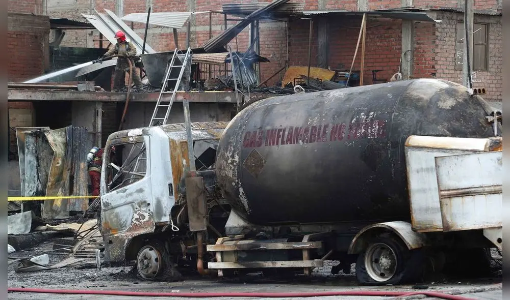Un bombero enfría con agua el techo de un camión cisterna de gas que explotó en el barrio de Villa María en Lima, Perú, el jueves 23 de enero de 2020. La explosión dejó dos muertos, aproximadamente 50 personas heridas y al menos una docena de casas quemadas. (AP Foto / Martín Mejía)