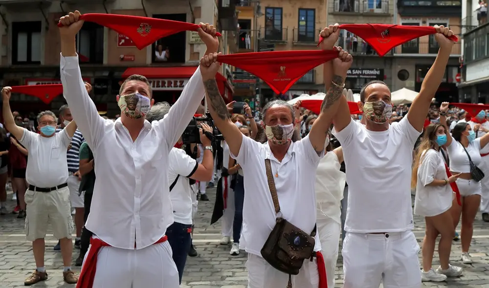 Revellers hold up traditional red scarves in front of the town hall where the firing of "chupinazo", which opens the San Fermin festival that was cancelled due to the coronavirus disease (COVID-19) outbreak, should have taken place, in Pamplona, Spain July 6, 2020. REUTERS/Jon Nazca