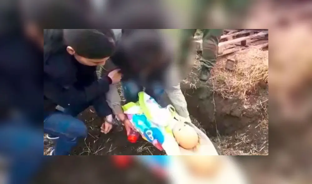 En la reconstrucción del crimen, Yulia usó una muñeca para mostrar cómo estranguló y enterró a su hijo de un año. Captura de video: Daily Mail.
