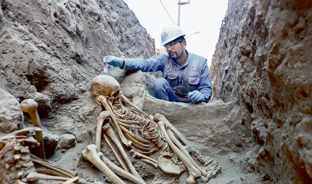 Hallazgo. El arqueólogo Jesús Bahamonde trabaja en una osamenta hallada en una recámara de adobe durante la excavación de una zanja para el gas. (Foto: Michael Ramón)