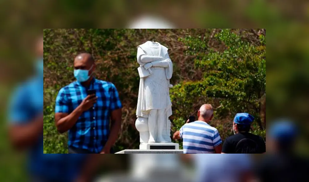 Personas fotografías la estatua que representa a Cristóbal Colón decapitada. Foto: Tim Bradbury/ AFP. Personas fotografías la estatua que representa a Cristóbal Colón decapitada. Foto: Tim Bradbury/ AFP.