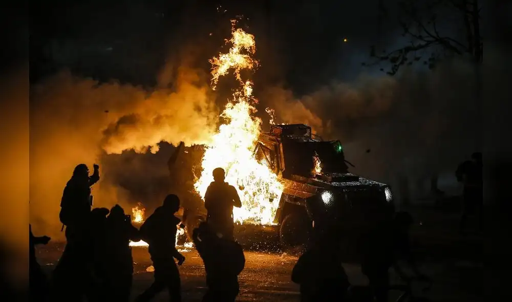 Los manifestantes queman un vehículo de la policía antidisturbios durante los enfrentamientos. Foto: AFP