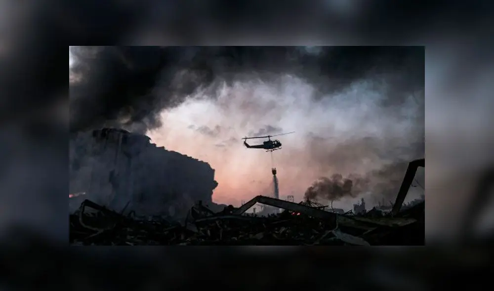 Un helicóptero apaga el incendio en el lugar de la explosión en el puerto de Beirut. Foto: AFP.