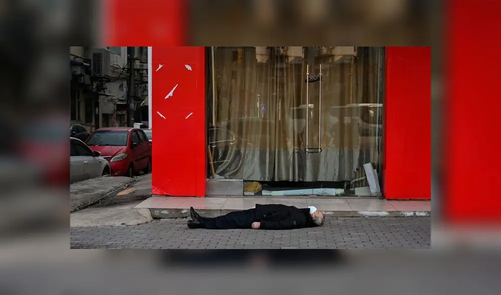 Un hombre sin vida permaneció tirado durante varias horas en plena calle de Wuhan. Foto: AFP Un hombre sin vida permaneció tirado durante varias horas en plena calle de Wuhan. Foto: AFP