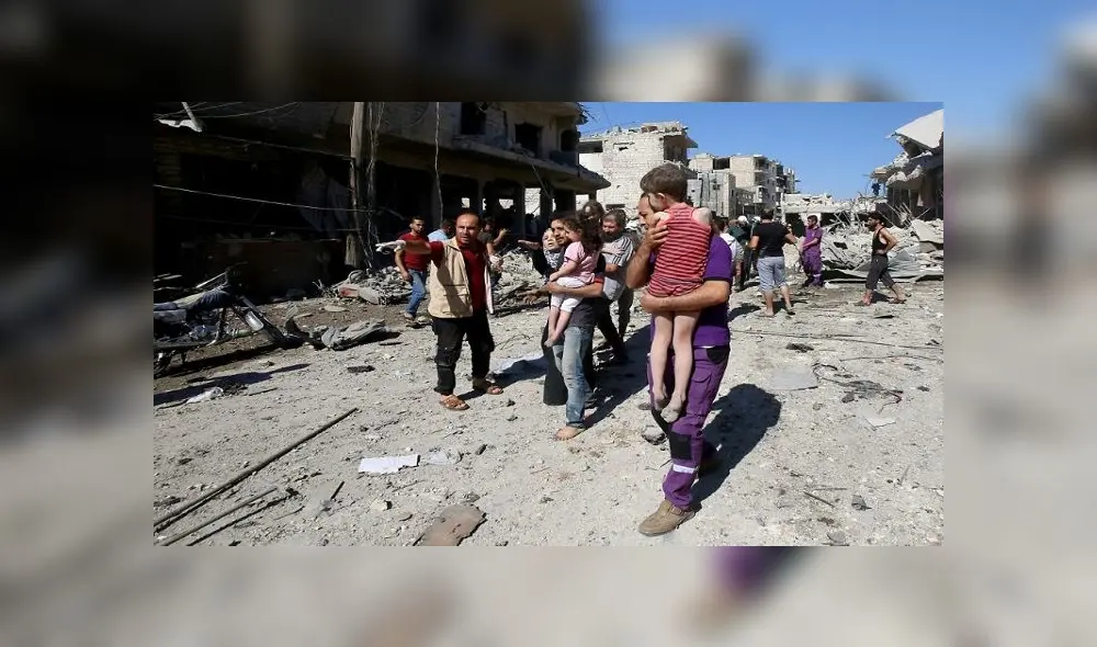 Un miembro de una oenegé humanitaria evacúa a un niño tras supuestos bombardeos rusos contra Maaret al Numan, ciudad del noroeste de Siria, el 22 de julio de 2019