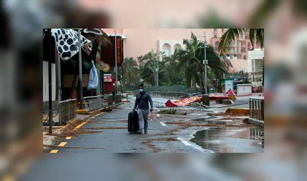 Un turista camina entre los escombros causados por el paso del huracán Delta. Foto: EFE Un turista camina entre los escombros causados por el paso del huracán Delta. Foto: EFE