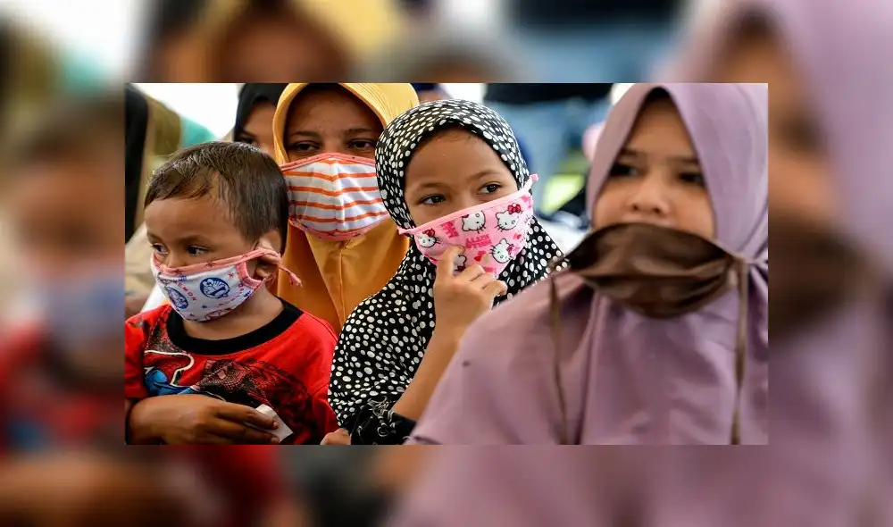 Women and children wearing face masks wait for food distribution amid the COVID-19 coronavirus pandemic in Blang Bintang, Aceh province on May 6, 2020. (Photo by CHAIDEER MAHYUDDIN / AFP) Women and children wearing face masks wait for food distribution amid the COVID-19 coronavirus pandemic in Blang Bintang, Aceh province on May 6, 2020. (Photo by CHAIDEER MAHYUDDIN / AFP)