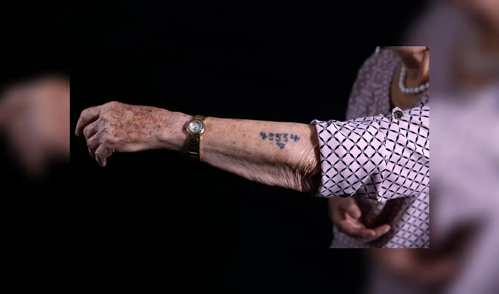 Una de las sobrevivientes a los campos de concentración de Auschwitz mostrando el tatuaje con que los marcaban. Foto: AFP