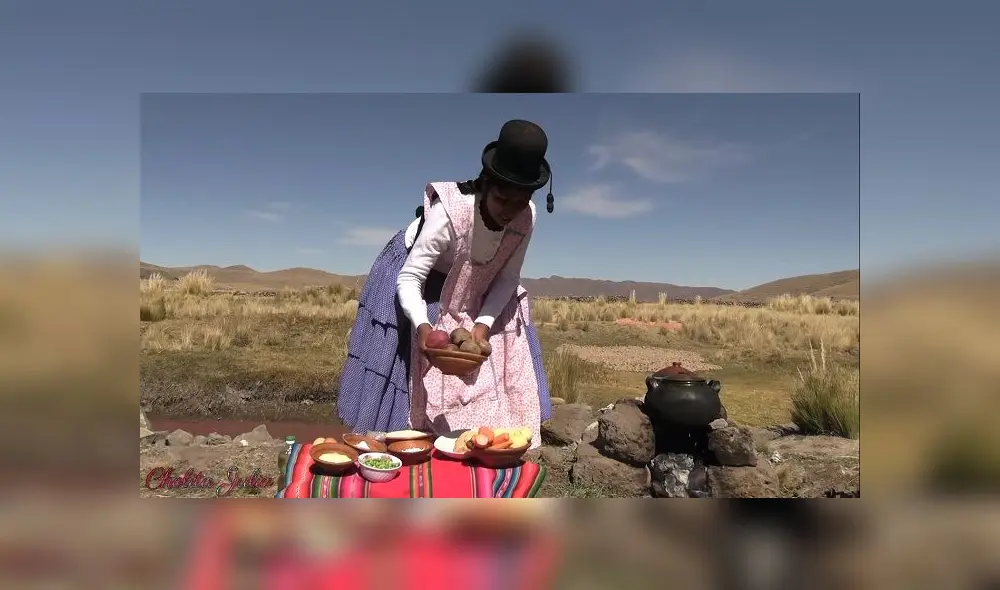 Al aire libre, en medio del campo, la Cholita Julia inicia a su estilo su nuevo video.