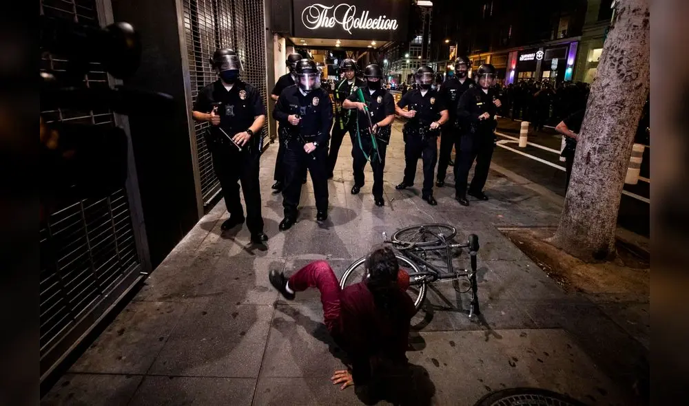Los Angeles (United States), 30/05/2020.- A woman falls off her bicycle as police officers prevent protesters from entering a street during protests over the Minnesota arrest of George Floyd, who later died in police custody, in Los Angeles, California, USA, 29 May 2020. A bystander's video posted online on 25 May, appeared to show George Floyd, 46, pleading with arresting officers that he couldn't breathe as an officer knelt on his neck. The unarmed black man later died in police custody. On 29 May, Hennepin County Attorney Mike Freeman announced third degree murder charges against the Minneapolis police officer who killed George Floyd. (Protestas, Estados Unidos) EFE/EPA/ETIENNE LAURENT

UNA MUJER SE CAE DE SU BICICLETA MIENTRAS AGENTES DE LA POLICIA IMPIDEN QUE LOS MANIFESTATES ENTREN A UNA CALLE DURANTE LAS PROTESTAS POR EL ASESINATO POLICIAL RACISTA //