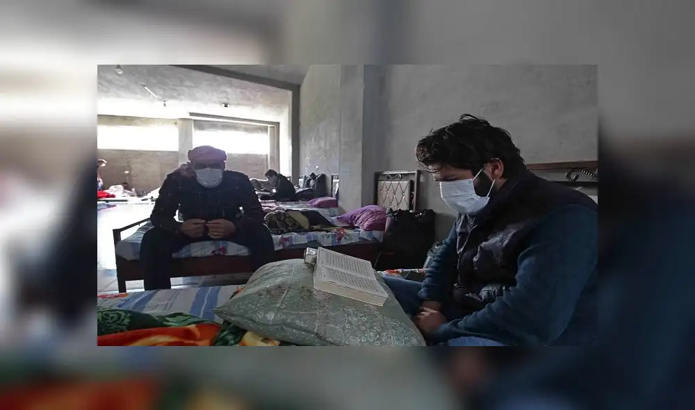 A Syrian man who returned from Turkey reads the Koran during the holy month of Ramadan at a quarantine facility in the countryside of the town of Jisr al-Shughur, west of the mostly rebel-held Syrian province of Idlib, on April 27, 2020 amid the coronavirus COVID-19 pandemic. (Photo by Abdulaziz KETAZ / AFP)