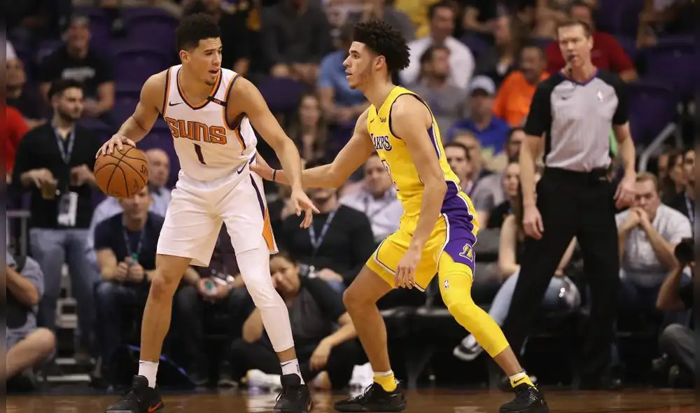 PHOENIX, AZ - NOVEMBER 13:  Devin Booker #1 of the Phoenix Suns handles the ball against Lonzo Ball #2 of the Los Angeles Lakers during the NBA game at Talking Stick Resort Arena on November 13, 2017 in Phoenix, Arizona. The Lakers defeated the Suns 100-93.  NOTE TO USER: User expressly acknowledges and agrees that, by downloading and or using this photograph, User is consenting to the terms and conditions of the Getty Images License Agreement.  (Photo by Christian Petersen/Getty Images)