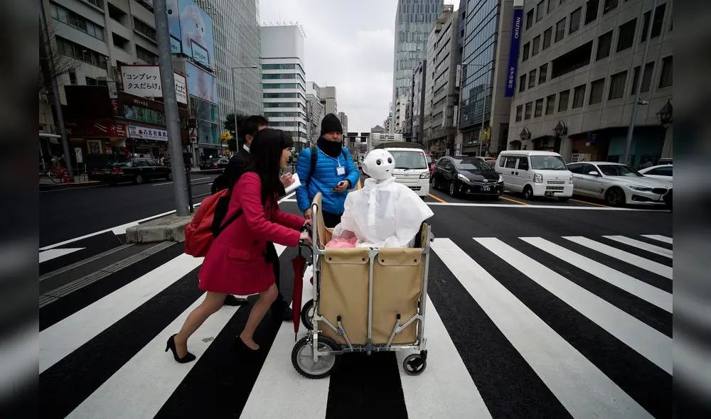 En Tokio, una mujer empuja un carrito con su robot humanoide Pepper.