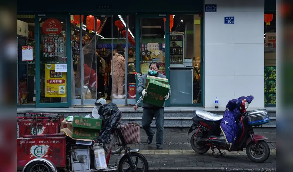 A man wearing a protective facemask carries boxes at a market in Wuhan on January 26, 2020, a city at the epicentre of a viral outbreak that has killed at least 56 people and infected nearly 2,000. - China on January 26 expanded drastic travel restrictions to contain an epidemic that has killed 56 people and infected nearly 2,000, as the United States, France and Japan prepared to evacuate their citizens from a quarantined city at the outbreak's epicentre. (Photo by Hector RETAMAL / AFP) A man wearing a protective facemask carries boxes at a market in Wuhan on January 26, 2020, a city at the epicentre of a viral outbreak that has killed at least 56 people and infected nearly 2,000. - China on January 26 expanded drastic travel restrictions to contain an epidemic that has killed 56 people and infected nearly 2,000, as the United States, France and Japan prepared to evacuate their citizens from a quarantined city at the outbreak's epicentre. (Photo by Hector RETAMAL / AFP)