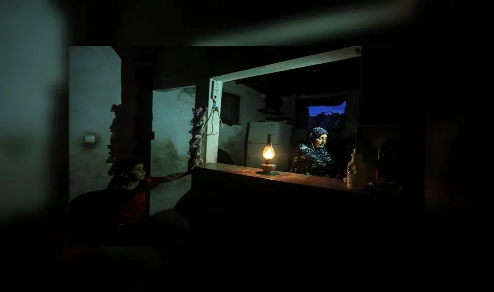 Una mujer palestina usa una lámpara de gas durante un corte de energía eléctrica después del cierre de la única planta de Gaza en medio de la tensión con Israel. Foto: MAHMUD HAMS / AFP. Una mujer palestina usa una lámpara de gas durante un corte de energía eléctrica después del cierre de la única planta de Gaza en medio de la tensión con Israel. Foto: MAHMUD HAMS / AFP.