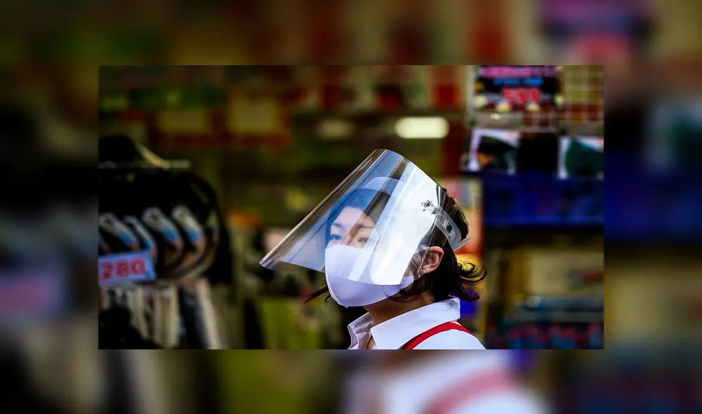 An employee wearing a face mask and a plastic shield, as a preventive measure against the spread of the COVID-19 coronavirus, waits for customers outside a shop in Sugamo district of Tokyo on Mau 24, 2020. - Prime Minister Shinzo Abe on May 21, 2020 lifted a state of emergency in several big cities in western Japan and hinted that the measure would be removed nationwide -- Tokyo and its neighbouring regions -- as early as next week. (Photo by Behrouz MEHRI / AFP) An employee wearing a face mask and a plastic shield, as a preventive measure against the spread of the COVID-19 coronavirus, waits for customers outside a shop in Sugamo district of Tokyo on Mau 24, 2020. - Prime Minister Shinzo Abe on May 21, 2020 lifted a state of emergency in several big cities in western Japan and hinted that the measure would be removed nationwide -- Tokyo and its neighbouring regions -- as early as next week. (Photo by Behrouz MEHRI / AFP)