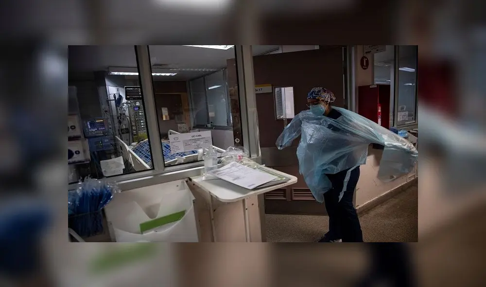 A doctor puts a protective gown as she gets ready to check patients at the Intensive Care Unit of the Barros Luco Hospital in Santiago, on July 22, 2020 amid the COVID-19 novel coronavirus pandemic. (Photo by Martin BERNETTI / AFP)