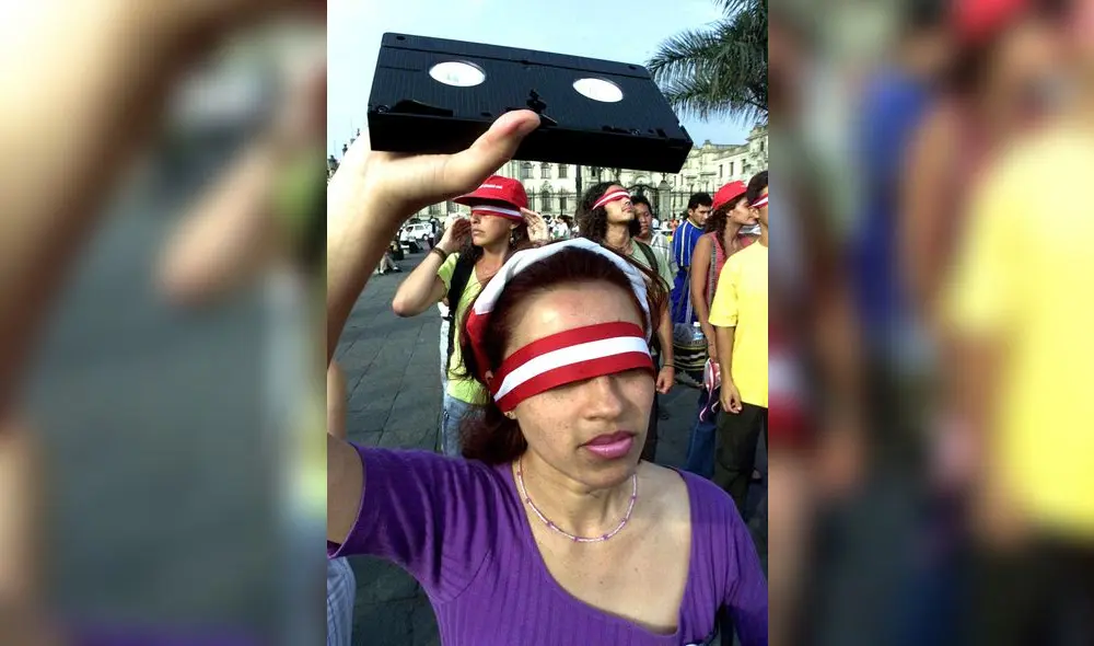 Una mujer con los ojos vendados muestra un cinta de video durante una protesta en favor de la exhibicion de los llamados "vladivideos" grabados por el profugo ex-asesor presidencial Valdimiro Montesinos, el 06 de febrero de 2001 en Lima. El escandalo ha suscitado reacciones encontradas en los sectores politicos frente a las elecciones del proximo 08 de abril, por lo que la opinion publica en general solicita la publicacion de todas las cintas antes de esa fecha.         AFP PHOTO/Jaime RAZURI