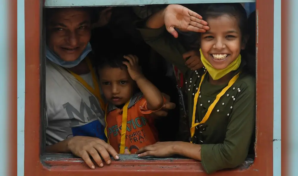 Young family members of migrant labourers react from a train window on their arrival from the Western Indian state of Rajasthan through a special train organised to bring back migrant labours and pilgrims to their hometowns at the Dankuni Railway station after the government eased a nationwide lockdown imposed as a preventive measure against the COVID-19 coronavirus, some 25 Km north of Kolkata on May 5, 2020. (Photo by Dibyangshu SARKAR / AFP) Young family members of migrant labourers react from a train window on their arrival from the Western Indian state of Rajasthan through a special train organised to bring back migrant labours and pilgrims to their hometowns at the Dankuni Railway station after the government eased a nationwide lockdown imposed as a preventive measure against the COVID-19 coronavirus, some 25 Km north of Kolkata on May 5, 2020. (Photo by Dibyangshu SARKAR / AFP)