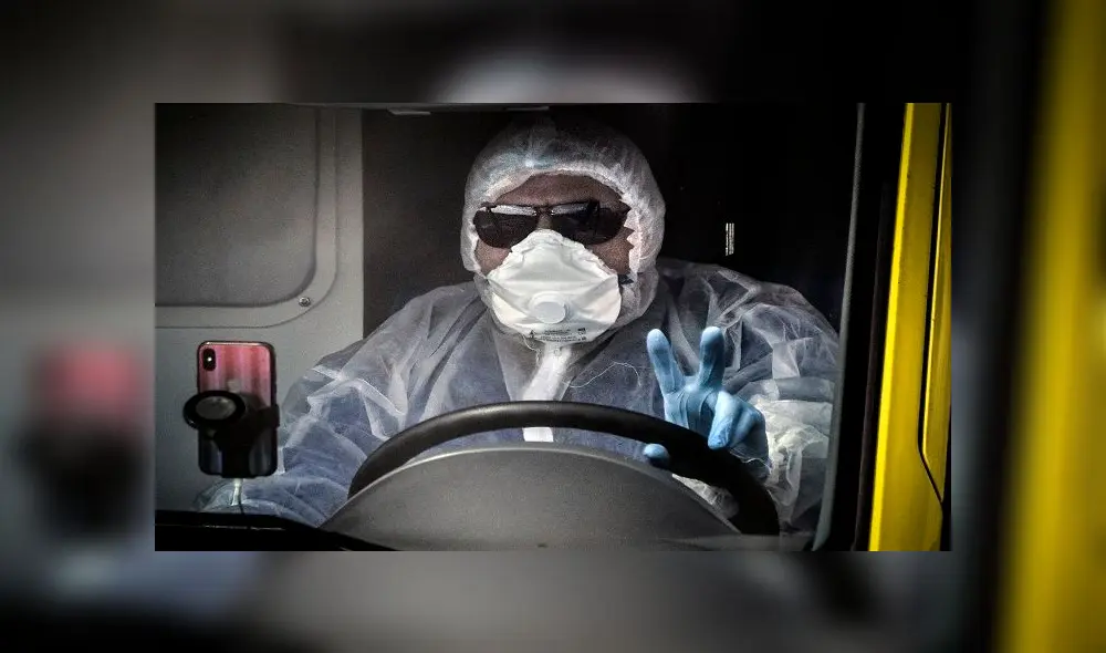An ambulance driver gives a victory sign while arriving to a hospital where patients infected with the COVID-19 novel coronavirus are being treated in the settlement of Kommunarka outside Moscow on April 28, 2020. (Photo by Alexander NEMENOV / AFP)