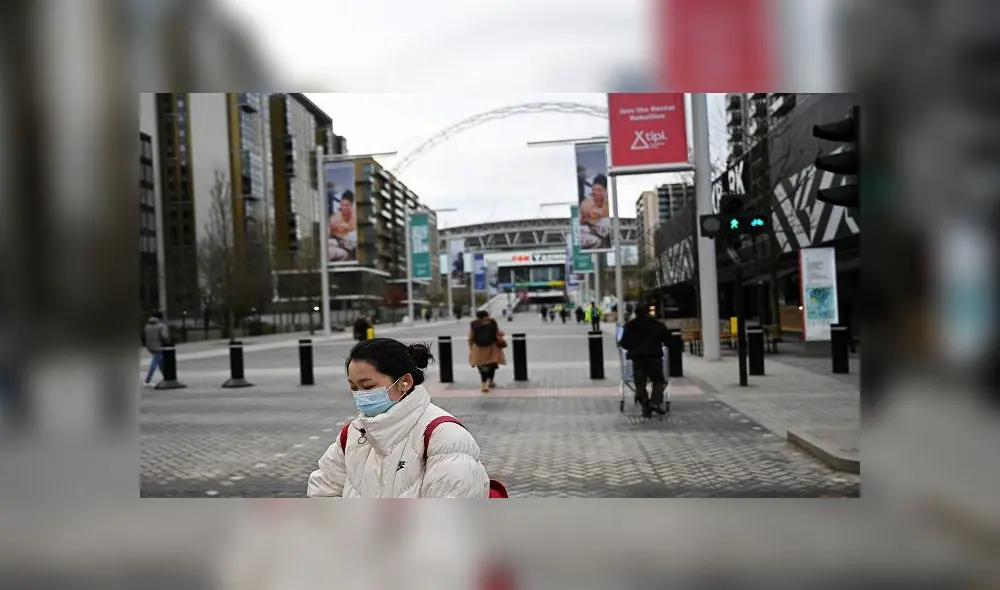 London (United Kingdom), 17/03/2020.- People wear face masks in front of the Wembley Stadium in north London, Britain, 17 March 2020. The UEFA meet on 17 March 2020 to discuss the effects of the coronavirus COVID-19 pandemic on the UEFA EURO 2020 and the European Cup competitions. The final of the UEFA EURO 2020 soccer tournament was scheduled to be played at Wembley Stadium on 12 July 2020. Several European countries have closed borders, schools as well as public facilities, and have cancelled most major sports and entertainment events in order to prevent the spread of the SARS-CoV-2 coronavirus causing the Covid-19 disease. (Lanzamiento de disco, Reino Unido, Londres) EFE/EPA/NEIL HALL