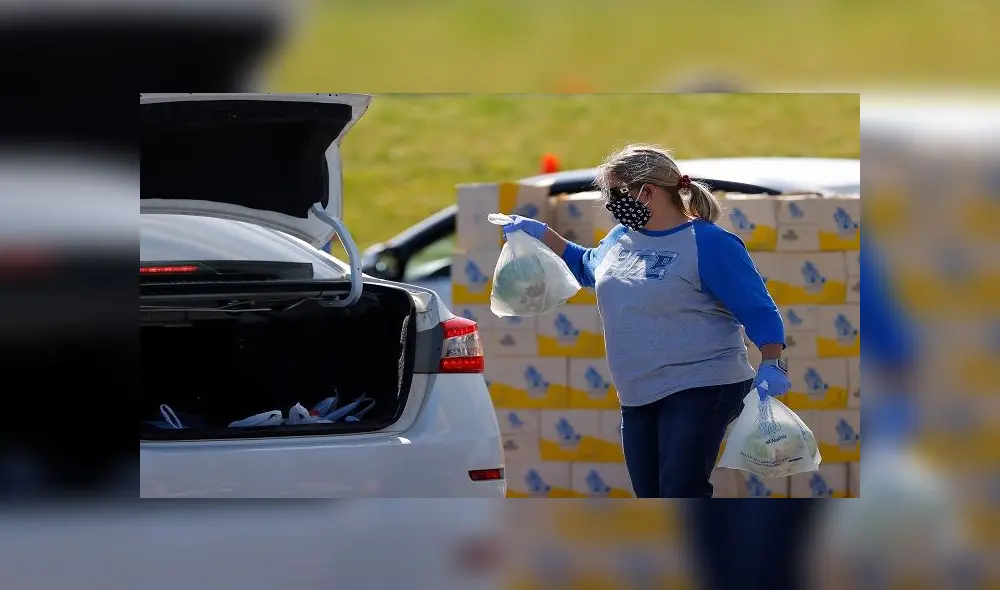 HAMPTON, GEORGIA - APRIL 17: A volunteer loads food into the back of a vehicle during a mobile market day at Atlanta Motor Speedway on April 17, 2020 in Hampton, Georgia. Atlanta Motor Speedway, Hampton Elementary, and the Atlanta Community Food Bank combined their efforts to provide food for all Hampton residents during this coronavirus (COVID-19) pandemic.   Kevin C. Cox/Getty Images/AFP