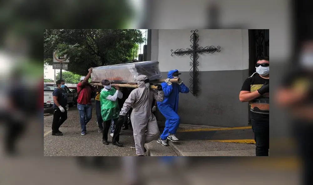 Relatives of a person who died from the new coronavirus -some in protective suits- carry the wrapped coffin inside a cemetery in the north of Guayaquil, Ecuador on April 17, 2020. (Photo by JOSE SANCHEZ LINDAO / AFP) Relatives of a person who died from the new coronavirus -some in protective suits- carry the wrapped coffin inside a cemetery in the north of Guayaquil, Ecuador on April 17, 2020. (Photo by JOSE SANCHEZ LINDAO / AFP)
