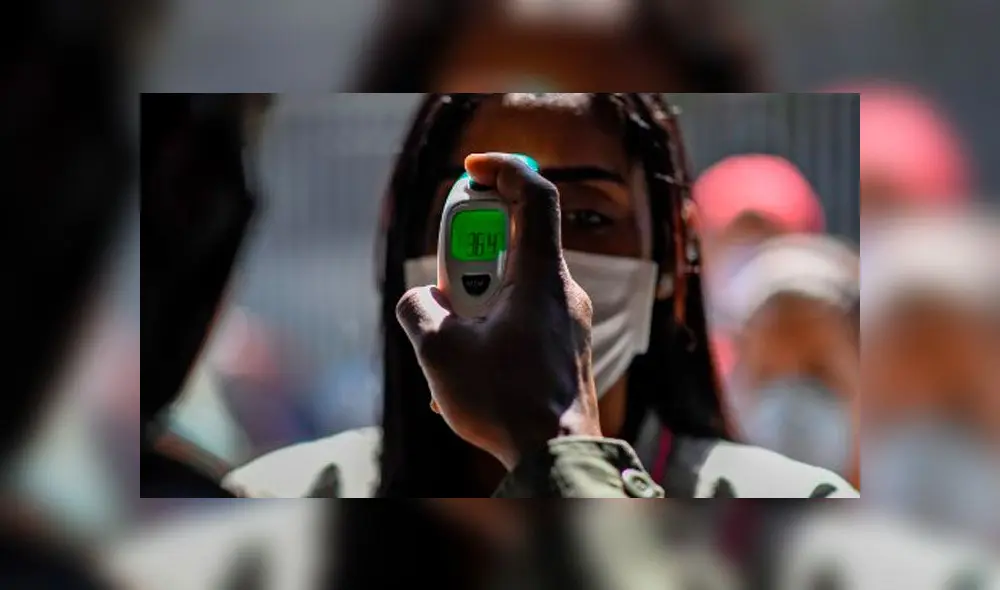 Militar toma temperatura a mujer en Venezuela. Foto: AFP. Militar toma temperatura a mujer en Venezuela. Foto: AFP.