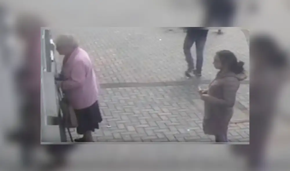 La delincuente se acercó silenciosamente a la anciana cuando estaba retirando dinero en un cajero automático La delincuente se acercó silenciosamente a la anciana cuando estaba retirando dinero en un cajero automático