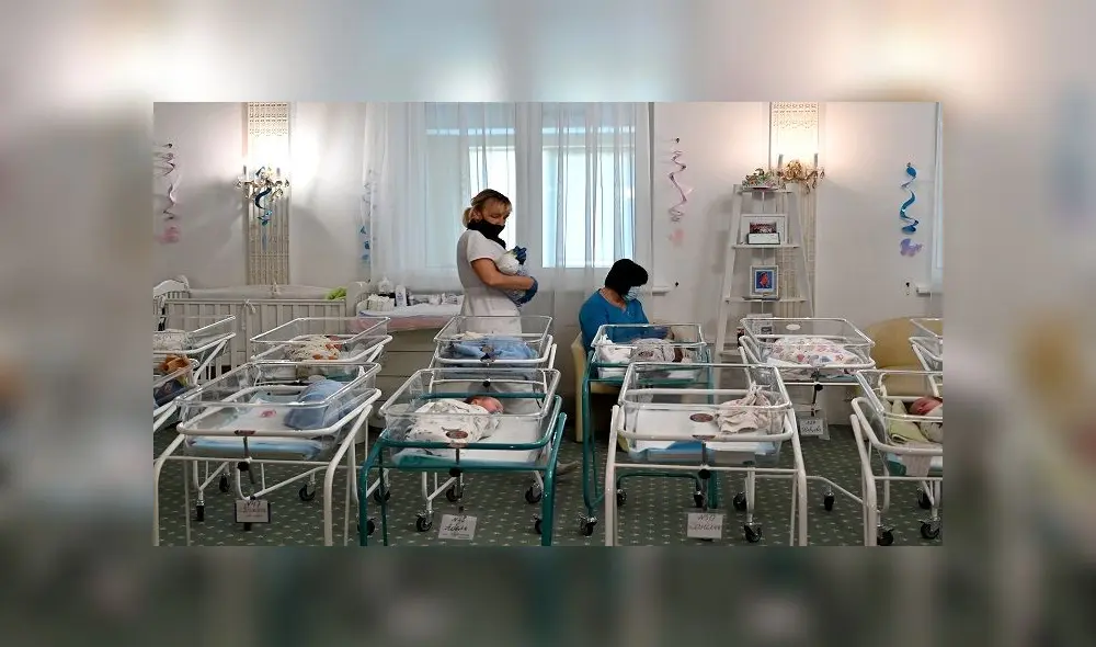 Nurses care for newborn babies at Kiev's Venice hotel on May 15, 2020. - More than 100 babies born to surrogate mothers have been stranded in Ukraine as their foreign parents cannot collect them due to border closures imposed during the coronavirus pandemic, authorities said on May 14. (Photo by Sergei SUPINSKY / AFP)