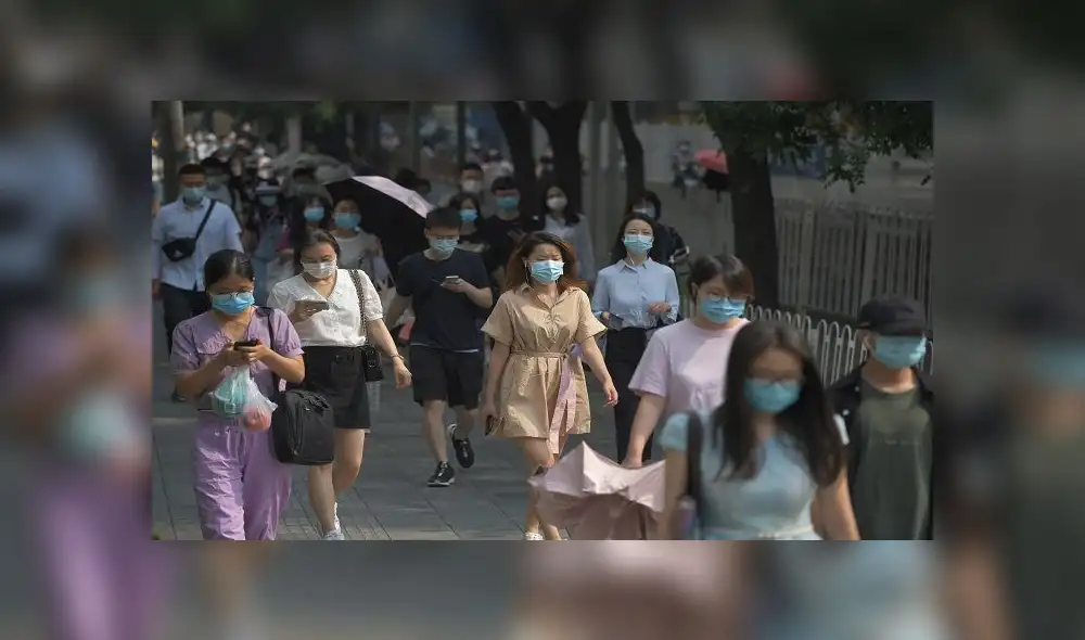People wear masks as they walk to work in Beijing on June 28, 2020. - Beijing has partially lifted weeks-long lockdown imposed in the Chinese capital to head off a feared second wave of coronavirus infections after three million samples were taken in two weeks, officials said. Dozens of residential compounds across the city were shut down, with authorities rolling out a mass testing campaign to root out any remaining cases. (Photo by GREG BAKER / AFP) People wear masks as they walk to work in Beijing on June 28, 2020. - Beijing has partially lifted weeks-long lockdown imposed in the Chinese capital to head off a feared second wave of coronavirus infections after three million samples were taken in two weeks, officials said. Dozens of residential compounds across the city were shut down, with authorities rolling out a mass testing campaign to root out any remaining cases. (Photo by GREG BAKER / AFP)
